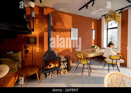 Interieur des Wohnzimmers mit Kamin und Essbereich im Loft-Stil Stockfoto