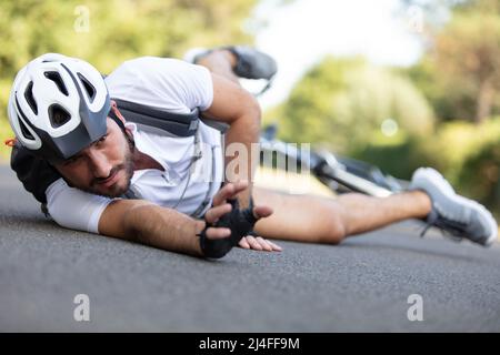 Mann Radfahrer fiel von Rennrad während des Radfahrens Stockfoto