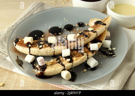 Konzept von leckeren Speisen mit Bananendessert auf Holztisch Stockfoto