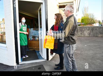 Brighton UK 15. April 2022 - Mark und Colette Hubert stehen am Karfreitagmorgen vor der Ravens Bakery in Brighton als erste in der großen Schlange, um ihre berühmten heißen Brötchen zu kaufen, bevor sie nach Liverpool aufbrechen, um ihre Enkel zu sehen : Credit Simon Dack / Alamy Live News Stockfoto