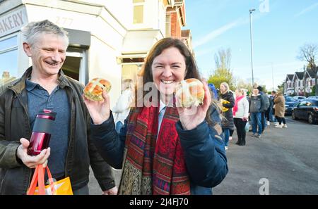 Brighton UK 15. April 2022 - Mark und Colette Hubert waren am Karfreitagmorgen die ersten in der großen Schlange vor der Ravens Bakery in Brighton, um ihre berühmten heißen Brötchen zu kaufen, bevor sie nach Liverpool aufbrechen, um ihre Enkel zu sehen : Credit Simon Dack / Alamy Live News Stockfoto