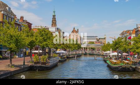 Blick auf den Koornbrug; eine feste Steinbogenbrücke mit einem Doppeldach über dem Wasser des Nieuwe Rijn im Zentrum der niederländischen Stadt Leiden. Stockfoto