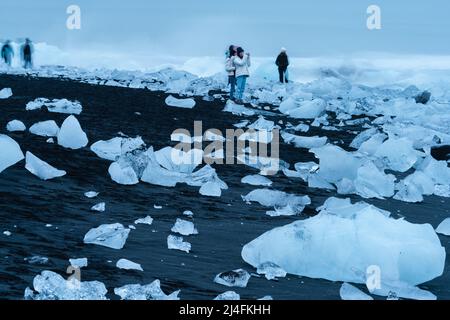 Nicht erkennbare Touristen, die Fotos am Diamantenstrand machen Stockfoto