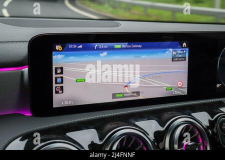 Eingebauter Navigationsbildschirm in einem Auto, der aus der Windschutzscheibe schaut Stockfoto