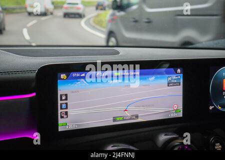 Eingebauter Navigationsbildschirm in einem Auto, der aus der Windschutzscheibe schaut Stockfoto