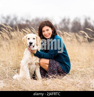 Fröhliche Frau mit hingebungsvollen Hund im Frühjahr Natur Stockfoto