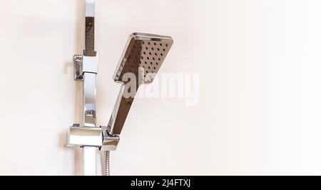 verchromte Regendusche in Nahaufnahme, die an der Wand hängt, Platz zum Kopieren von Kleister für Design Stockfoto
