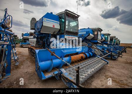 Provinz Kyzylorda, Kasachstan - 01. Mai 2012: Moderne Mähdrescher kombinieren Maschinen auf dem Bauernhof. Grauer Himmel, Wolken Stockfoto