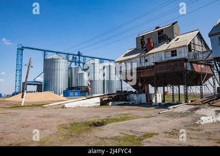 Provinz Nordkasachstan, Kasachstan - 12. Mai 2012: Alte sowjetische Getreidelagerung (rechts) und moderne Stahlaufzugssilos (links) Stockfoto