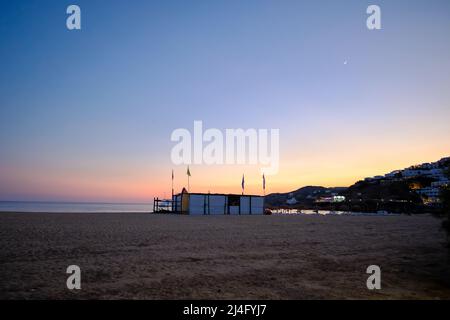 Blick auf ein geschlossenes Wassersportzentrum am Strand von Mylopotas iOS und einen wunderschönen Sonnenuntergang Stockfoto