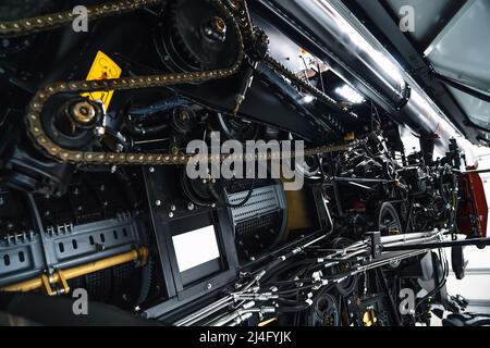 Harvester-Motor, Getriebe-Ketten, Mechanismen Übertragung der neuen modernen Technologie kombinieren Fahrzeugmotor mit Metall, Chrom, Kunststoffteile, schwere landwirtschaftliche Geräte, selektive Fokus. Stockfoto