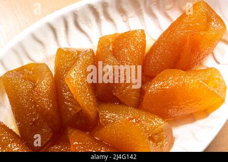 Bitterorange Dessert auf einem weißen Teller. Traditionelle mediterrane Küche Dessert Nahaufnahme. Traditionelles türkisches Dessert mit frischen Zitrusfrüchten Stockfoto