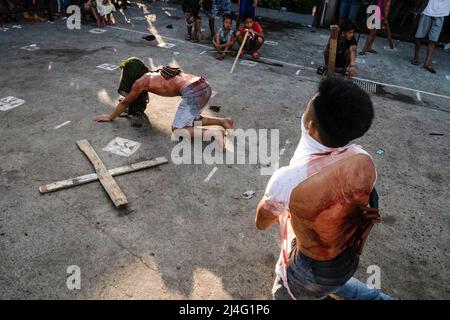 Navotas, Philippinen. 15. April 2022. (ANMERKUNG DER REDAKTION: Das Bild enthält grafische Inhalte) Flagellen mit blutigem Rücken peitschen sich während der karfreitagsfastenriten in Navotas. Viele philippinische Katholiken begehen die Karwoche, indem sie sich verschiedenen Formen der körperlichen Buße unterwerfen, in der Hoffnung, für ihre Sünden vergeben zu werden. (Foto von Oliver Haynes/SOPA Images/Sipa USA) Quelle: SIPA USA/Alamy Live News Stockfoto