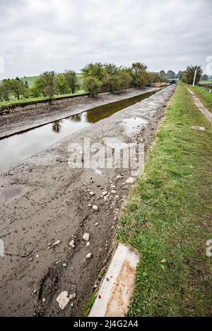 Entwässertes Kanalgebiet auf dem Leeds & Liverpool Kanal ( Gargrave-Seite von Carfenters Lock @ April 202)..Narrowboats würden normalerweise hier festgemacht werden. Stockfoto