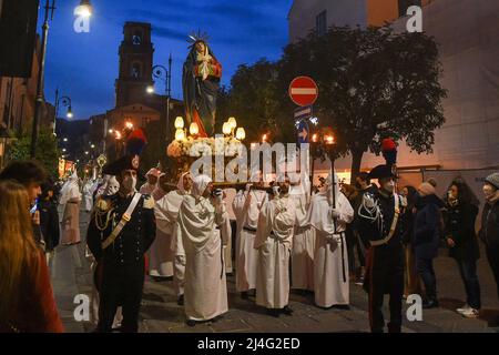 Sorrento, Italien. 14. April 2022. Kapuzen-Büßer der Arciconfraternita di Santa Monica tragen Kreuze und Fackeln, während sie an der Karfreitagsprozession entlang der Straßen von Sorrento Süditalien teilnehmen. Christliche Gläubige auf der ganzen Welt feiern die Osterwoche zur Feier der Kreuzigung und Auferstehung Jesu Christi. Sorrento am 15. April 2022 in Neapel, Italien. Quelle: Franco Romano/Alamy Live News Stockfoto