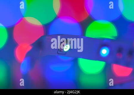 Helle, farbenfrohe LED-Leuchten leuchten im Dunkeln, Nahaufnahmen mit selektivem Fokus und Bokeh-Effekt Stockfoto