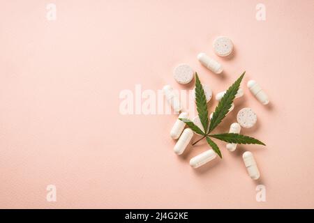 CBD-Öl in Glasflaschen und Cannabisblätter am weißen Tisch. Stockfoto