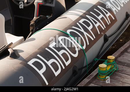 Fischschutz-Patrouillenboot-Rumpffragment mit Textaufkleber auf Russisch. Die Übersetzung ins Englische ist Fish Guarding Stockfoto