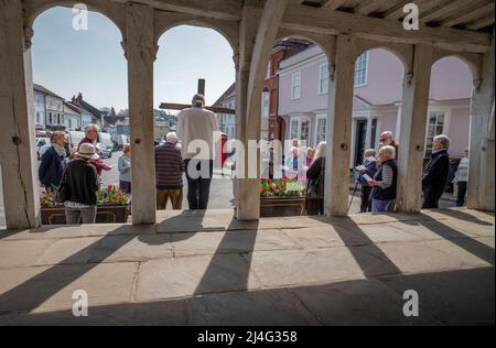 Thaxted, Essex, Großbritannien. 15. April 2022. Karfreitag, Osterprozession des Zeugen durch Thaxted Essex, Großbritannien. 15. April 2022. Daniel Fox trägt das Kreuz, während er die Prozession des Zeugnisses durch die alte nordwestliche Essex-Stadt Thaxted führt. Mitglieder der katholischen, anglikanischen, Baptisten und Vereinigten reformierten Kirchen waren anwesend. Gesehen hier außerhalb der 14. Cent. Thaxted Guildhall. Kredit: BRIAN HARRIS/Alamy Live Nachrichten Stockfoto