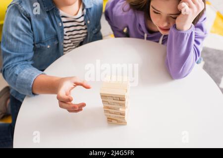 Draufsicht auf Teenager spielen Holzklötze Spiel in der Nähe Freund mit Down-Syndrom zu Hause Stockfoto