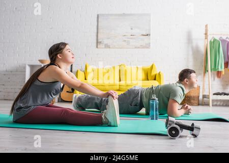 Seitenansicht von Teenagern mit Down-Syndrom-Training auf Fitnessmatten zu Hause Stockfoto