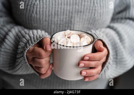 Frau, die leckeren Kakao mit Marschmalow in der Hand hält Stockfoto