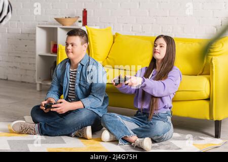 KIEW, UKRAINE - 21. JANUAR 2022: Jugendliche mit Down-Syndrom spielen zu Hause Videospiele Stockfoto