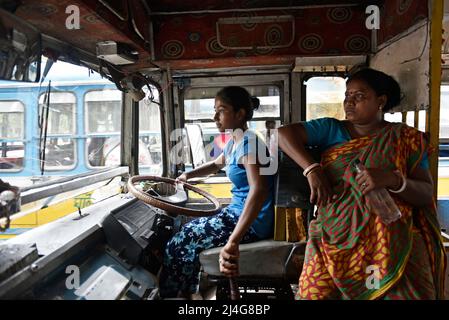 Kalkutta, Westbengalen, Indien. 15. April 2022. Kalpana Mondal, 19 Jahre alt, fährt am 15. April 2022 in Kalkata, Indien, einen privaten Linienbus. Sie übernahm die Verantwortung, nachdem ihr Vater vor vier Jahren beim Fahren des Busses einen Unfall hatte. Jetzt hilft ihr Vater ihr als Chefin des Busses und sie bleibt bei ihr, während sie den Bus fährt, um ihre Familie finanziell stabil zu machen. (Bild: © Indranil Aditya/ZUMA Press Wire) Stockfoto