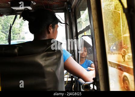 Kalkutta, Westbengalen, Indien. 15. April 2022. Kalpana Mondal, 19 Jahre alt, fährt am 15. April 2022 in Kalkata, Indien, einen privaten Linienbus. Sie übernahm die Verantwortung, nachdem ihr Vater vor vier Jahren beim Fahren des Busses einen Unfall hatte. Jetzt hilft ihr Vater ihr als Chefin des Busses und sie bleibt bei ihr, während sie den Bus fährt, um ihre Familie finanziell stabil zu machen. (Bild: © Indranil Aditya/ZUMA Press Wire) Stockfoto