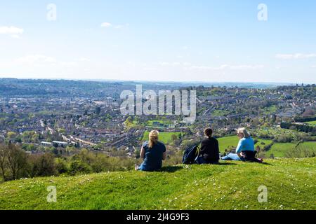 Batheaston, Somerset, UK Wetter. 15.. April 2022. An einem schönen sonnigen Tag bewundern die Menschen auf Little Solsbury Hill die Aussicht auf Bath Spa. Der ehemalige Festung-Hügel aus der Eisenzeit wurde durch den Peter Gabriel-Hit „Solsbury Hill“ berühmt. Stockfoto