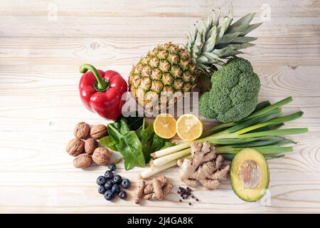Vegetarisches Essen für eine entzündungshemmende Ernährung mit Gemüse, Nüssen, Früchten und Gewürzen auf hellem Holzhintergrund, Hochwinkel von oben, Kopie Stockfoto