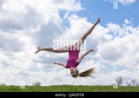 Birmingham, Großbritannien. 15. April 2022. Die 17-jährige Tanzstudentin Amelia Hubbard aus Halesowen, West Midlands, fährt in den Park im Süden von Birmingham, um einige Frühlingsbewegungen zu machen, da die Temperaturen in Großbritannien am Karfreitag ansteigen. Kredit: Peter Lopeman/Alamy Live Nachrichten Stockfoto