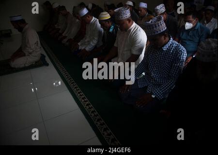 Muslimische Asylsuchende werden gesehen, wie sie während des heiligen Ramadan in einem vorübergehenden Flüchtlingsheim in Medan, Provinz Nord-Sumatra, Indonesien am 15. April 2022 zusammen beten, während der Teil der Internatsausbildung blinkt. Mit dieser einwöchigen Ausbildung hofft die Internationale Organisation für Migration durch die Geutanyoe-Nichtregierungsorganisation, bis zu 60 Teilnehmer des Flash-Internats, nämlich Generationen von Asylbewerbern aus Myanmar, Afghanistan und Birma in Indonesien, durch eine nichtformale Ausbildung auszustatten, bevor sie Asyl aus anderen Ländern erhalten, Sagte der Coordi Stockfoto