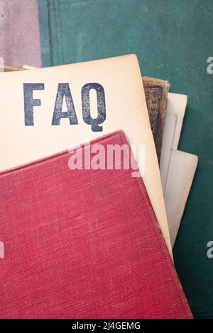 FAQ geschrieben mit gestempelten Buchstaben auf einem vergilbten Stück Papier Stockfoto