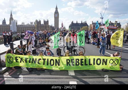 Demonstranten nehmen an einem Extinction Rebellion Protest auf der Westminster Bridge in London Teil. Bilddatum: Freitag, 15. April 2022. Stockfoto