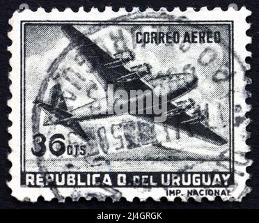 URUGUAY - UM 1958: Eine in Uruguay gedruckte Marke zeigt ein viermotorisiertes Flugzeug, um 1958 Stockfoto