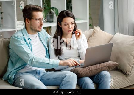 Ein junges Paar arbeitet vor einem Laptop. Stockfoto