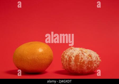 Mandarinorangen auf rotem Hintergrund Stockfoto