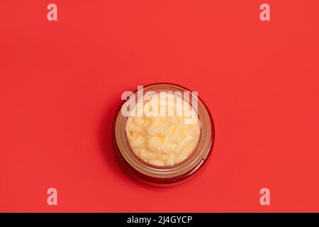 Gesichtscreme in einem Glas Kosmetikglas auf einem farbigen Hintergrund Stockfoto