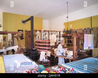 Toronto, Kanada - 08 11 2011: Museumsarbeiter als Weber im Inneren des Weberladens aus dem 19.. Jahrhundert im Open-Air-Museum Black Cree Stockfoto