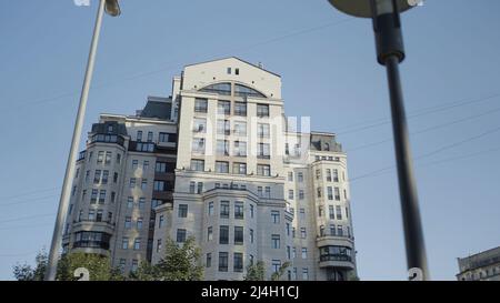 Moskauer Wohnkomplex. Aktion. Ein mehrstöckiges Gebäude neben Bäumen vor blauem Himmel. Stockfoto
