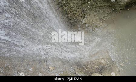 Bergwasserfall. Aktion. Dünne Bäche mit Wassertropfen laufen über Bergfelsen und fallen hinunter. Stockfoto