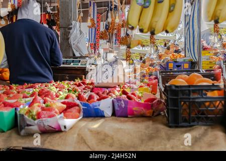 Erdbeeren zum Verkauf in Birkhadem Markthalle Obst und Gemüse. Erdbeerdosen, Preis auf arabisch. Orangen, Bananen, Datteln und altes Gleichgewicht. Stockfoto