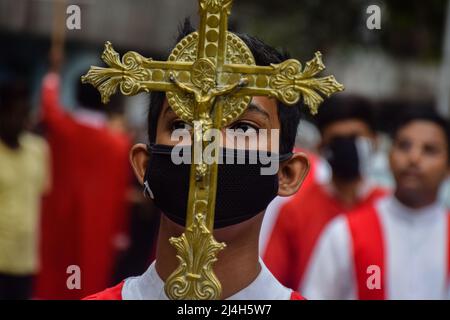 Rajpur Sonarpur, Westbengalen, Indien. 15. April 2022. Ein junger katholischer Anhänger hält während einer Karfreitagsprozession in Kalkutta ein Kruzifix. (Bild: © Sankhadeep Banerjee/ZUMA Press Wire) Stockfoto