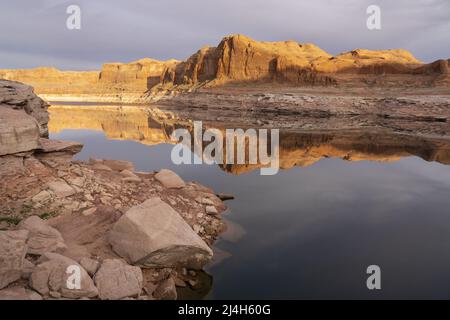 Klippen, die sich bei Sonnenuntergang über Lake Powell erheben, Lake Powell, Glen Canyon National Recreation Area, Kane County, Utah, USA Stockfoto