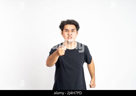Wütender junger Mann, der mit dem Finger nach vorne zeigt und schreit Stockfoto