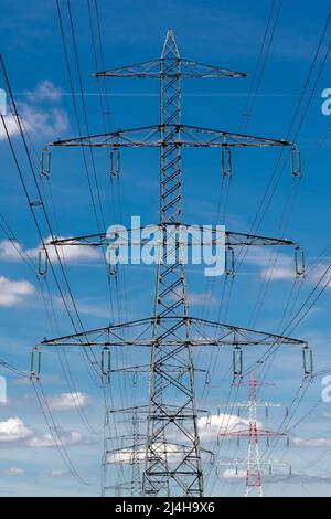 Metallmast, der über den Kopf liegende elektrische Kabel von Hochspannungsleitungen trägt. Konzepte der elektrischen Übertragungsnetze, Energieversorgung, Stromverbrauchsfragen Stockfoto