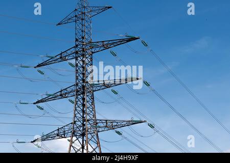 Metallmast, der über den Kopf liegende elektrische Kabel von Hochspannungsleitungen trägt. Konzepte der elektrischen Übertragungsnetze, Energieversorgung, Stromverbrauchsfragen Stockfoto