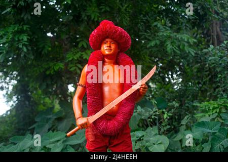 Munshiganj, Bangladesch. 13. April 2022. Ein Anhänger posiert mit seinem Schwert für ein Foto vor der Lal-Kach-Prozession am allerletzten Tag des Jahres in Bangladesch. Das Lal Kach (Rotes Glas) Festival wird in der lokalen Gemeinde seit vielen Jahrzehnten gefeiert. Die Hindu-Männer malen sich rot an und nehmen an einer Prozession mit Schwertern Teil, während sie Macht gegen böse Sprites zeigen, während sie ein Jahr beenden und ein weiteres bangladesches Neujahr begrüßen. (Foto von Ziaul Haque Oisharjh/SOPA Images/Sipa USA) Quelle: SIPA USA/Alamy Live News Stockfoto