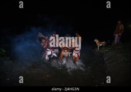 Tehatta, Westbengalen, Indien. 14. April 2022. Das 'Hajrha Bhasan'-Ritual ist Teil des ländlichen Gajan-Festivals in Bengalen, wo um Mitternacht (1:27 UHR) Ein hingebungsvoller Mönch versuchte zu entkommen, indem er ohne Sicherheit nach dem Ritual zum Jalangi-Fluss sprang und der Rest der Mönche nahm ihn auf, nahm ihn an den Ufern des Flusses mit und rann in Sekundenbruchteilen direkt zu seinem Ziel. Dieses Foto wurde in Tehatta, Westbengalen, aufgenommen. (Bild: © Soumrabyata Roy/Pacific Press via ZUMA Press Wire) Stockfoto